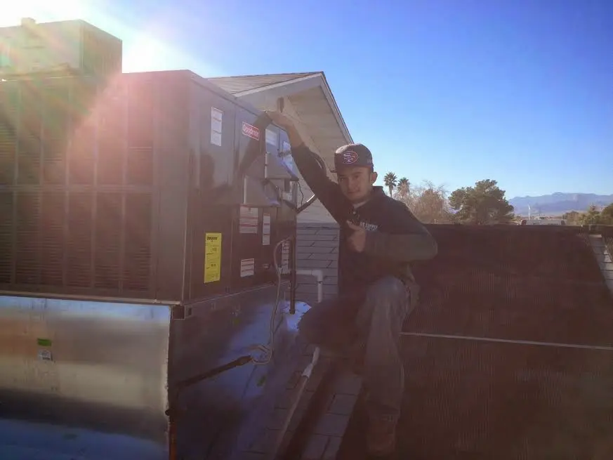 HVAC technician performing Boiler Repair on a rooftop unit in Clemmons